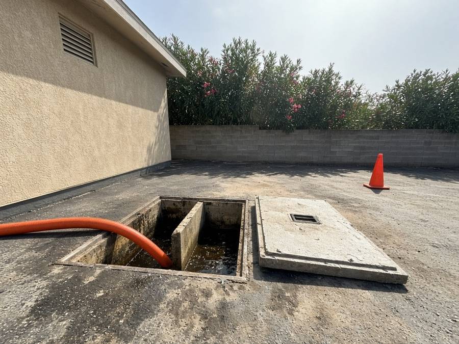 Open in-ground grease interceptor with the concrete lid removed — grease trap cleaning in Fullerton, CA